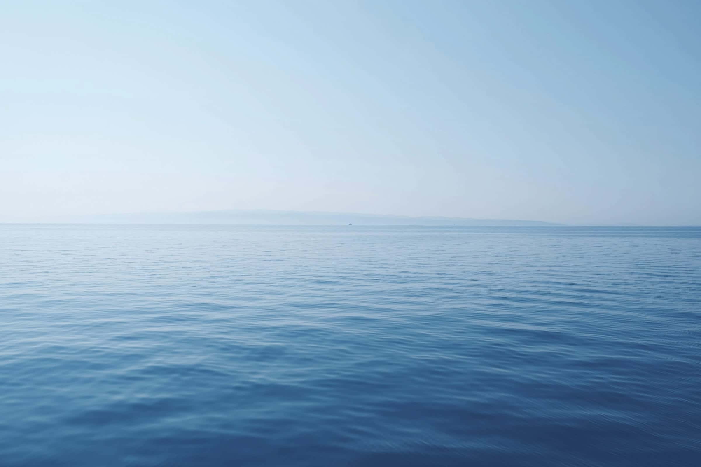 A calm blue sea meeting a clear horizon