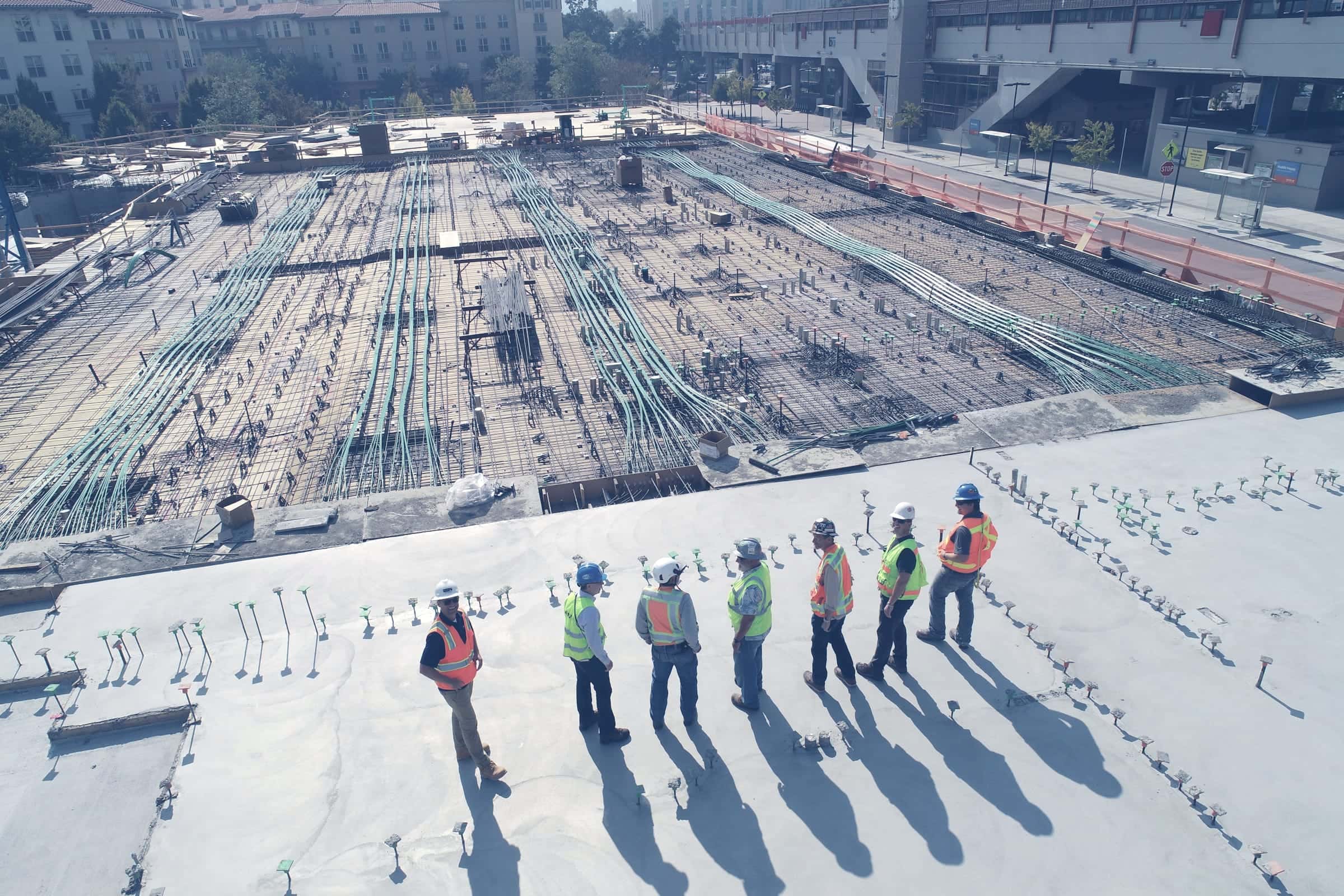 Engineers in safety gear standing on a large construction site